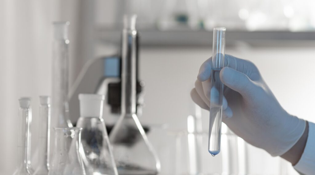close up hand holding tube with solution